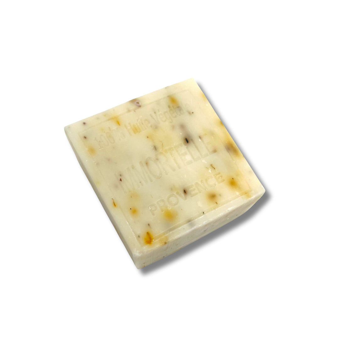 Savonitto artisanal à l’immortelle 100g avec fleurs séchées exfoliantes visibles.