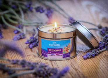 Bougie parfumée à la lavande dans une boîte métal, entourée de brins de lavande séchée, ambiance Provence