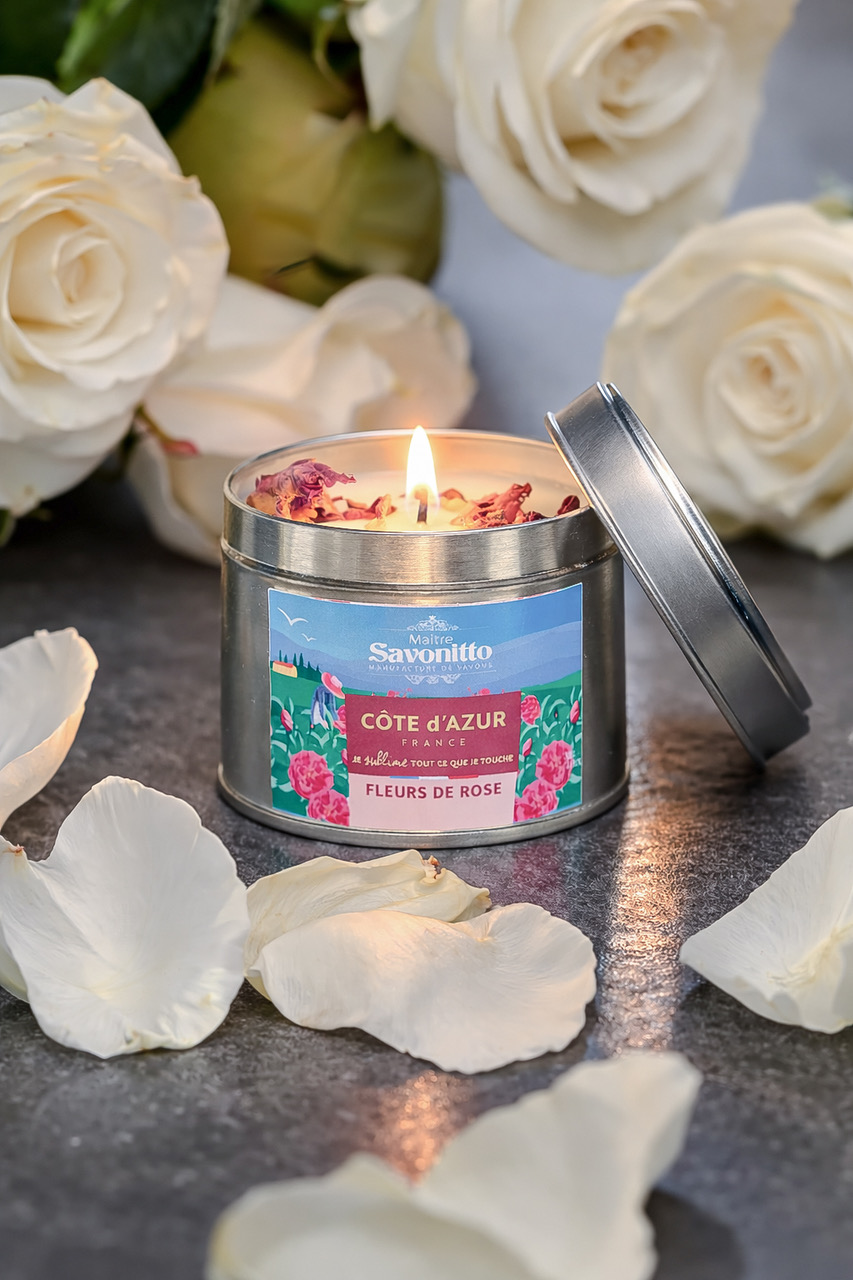 Bougie parfumée à la rose dans une boîte métal, entourée de pétales de rose blanche, ambiance élégante
